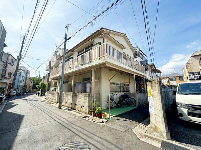 This 49-year-old wooden home features 3 bedrooms, 2 living rooms, 2 dining rooms, and 2 kitchens